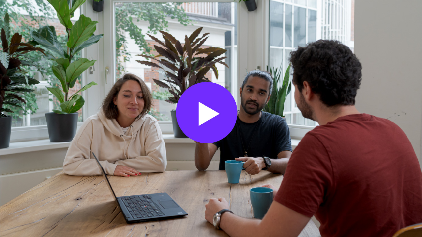 Three people sat around a table